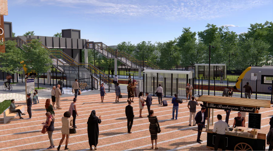 A crowd of people walking towards the new train station in North Bristol at Brabazon.