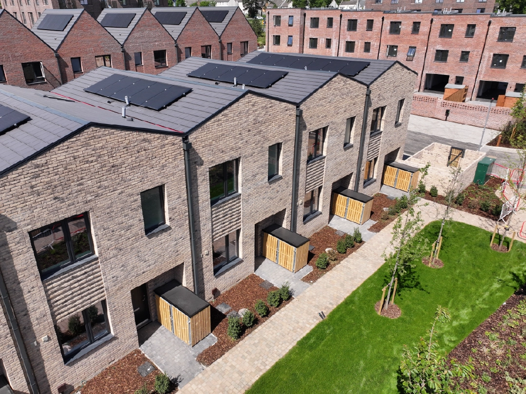 Aerial view of The Skylark house type at Brabazon, a row of modern, two-storey brick townhouses with solar panels, surrounded by a living street. 