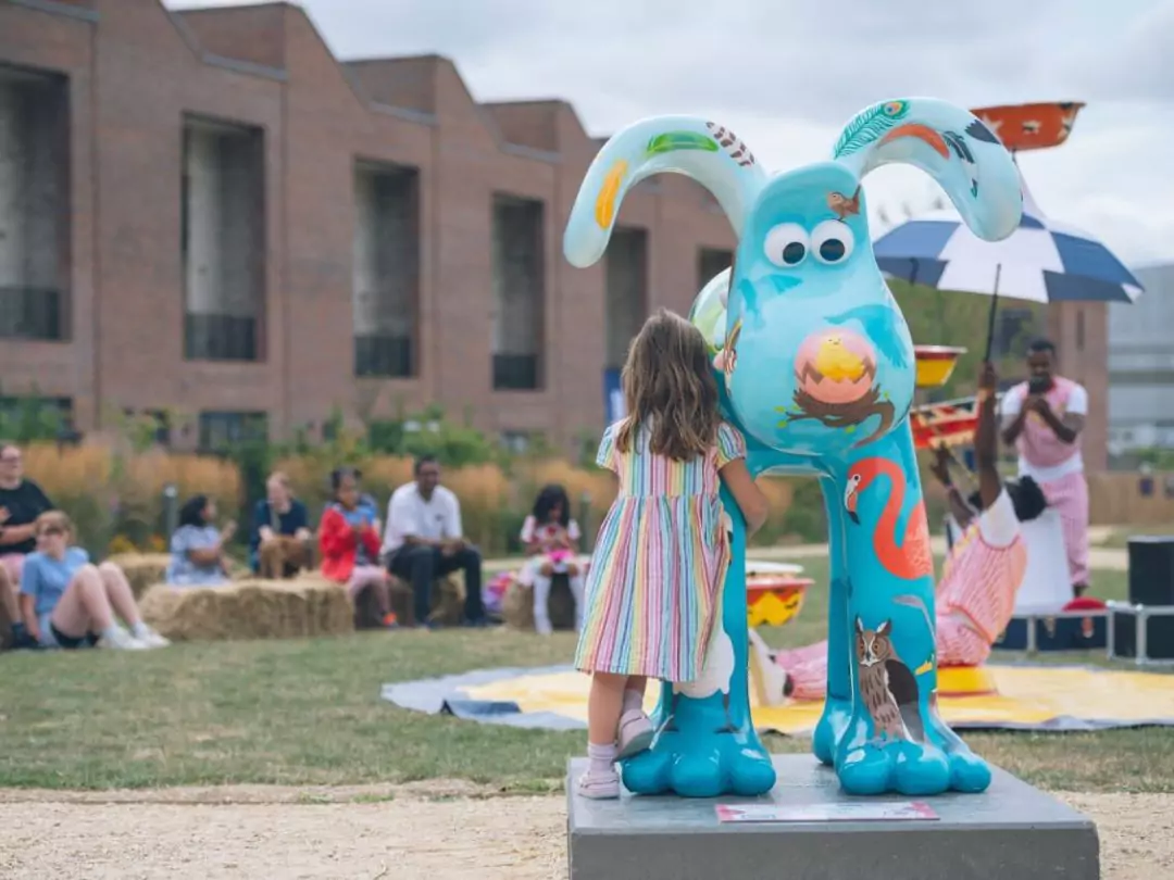 Girl holds on to Gromit: 'The Birds' at Brabazon while watching a circus performance in celebration of Gromit Unleashed 3 at Brabazon. 
