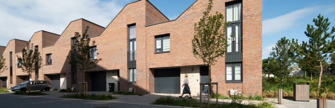 Street view of contemporary brick terrace houses along a tree-lined street at Brabazon. 