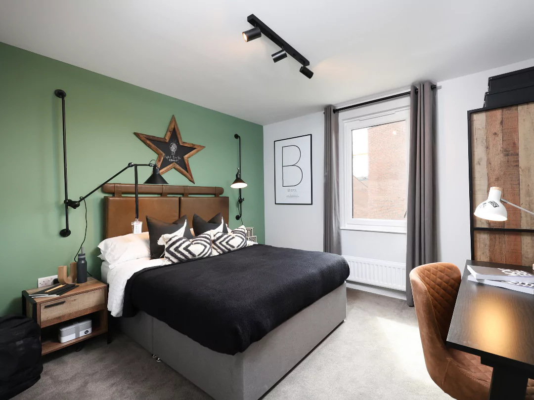 Teenage double bedroom featuring moody styling, a work desk and green feature wall.